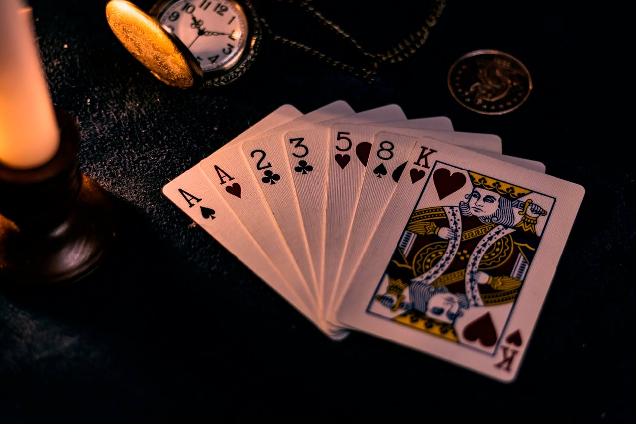 our-services-01 A dimly lit close-up of playing cards with a pocket watch, showcasing a nostalgic casino vibe.